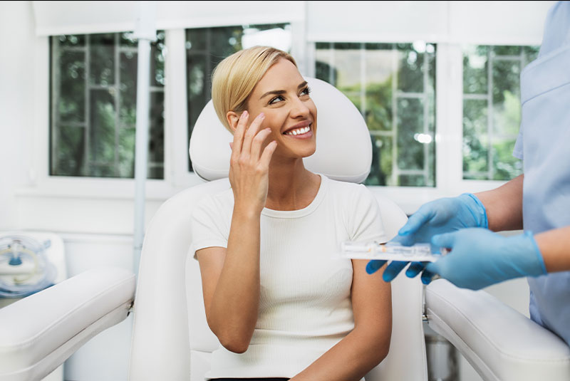 Beautiful and happy blonde woman at dental clinic.