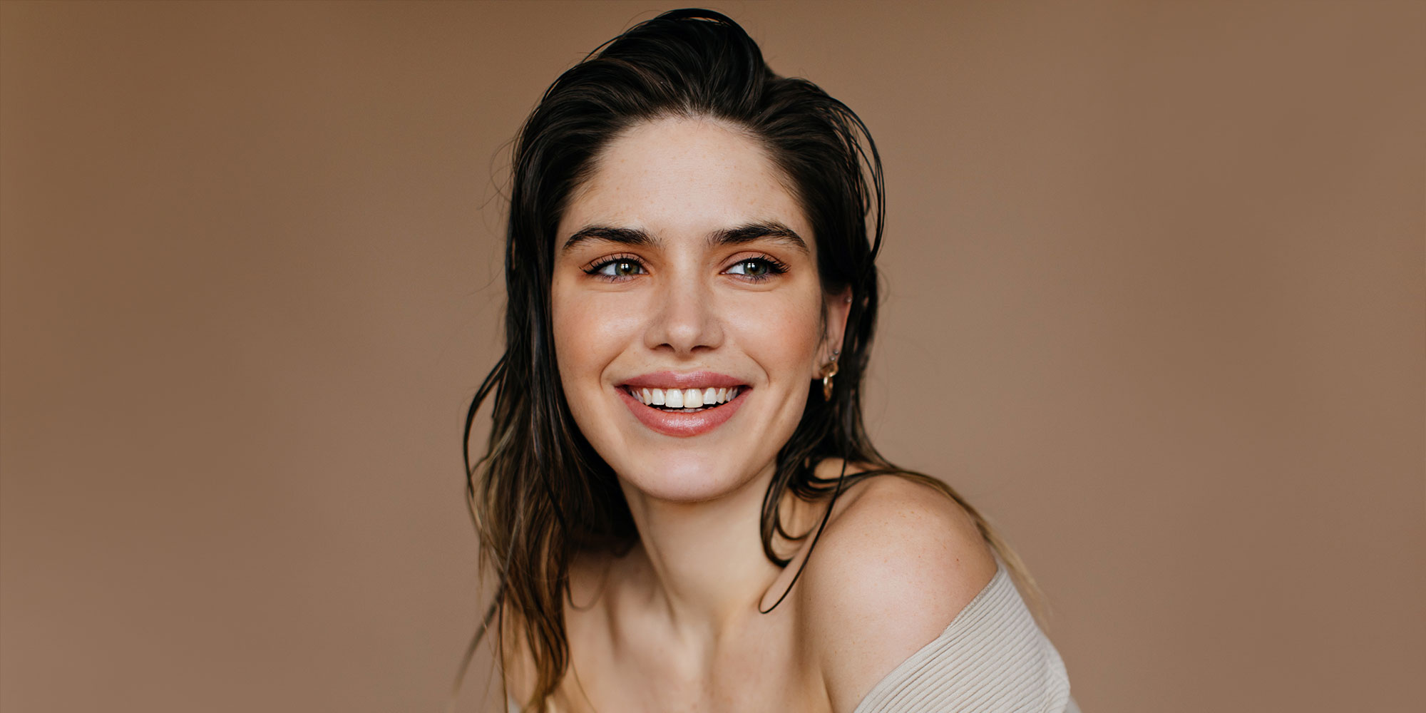 Cheerful caucasian girl smiling on brown background. Studio portrait of charming female model