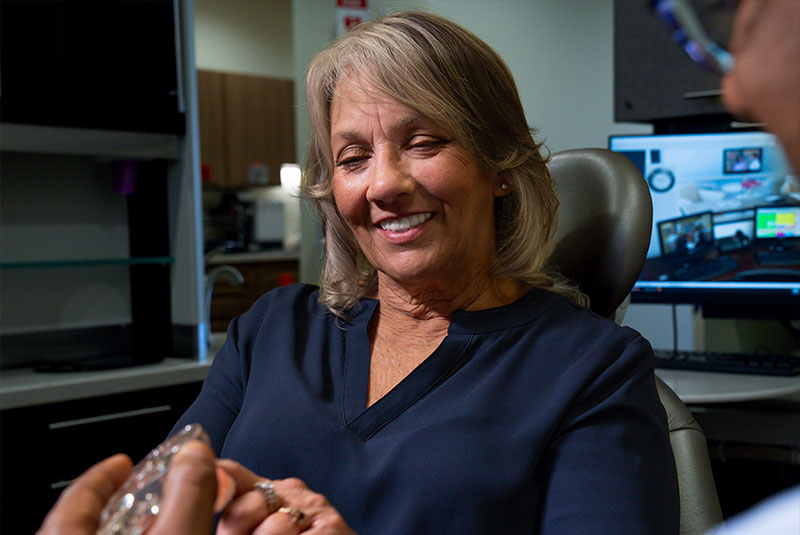 patient looking at dental implant model within the dental center