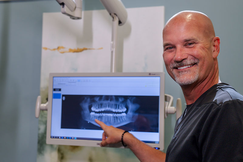doctor going over x ray display information with dental patient