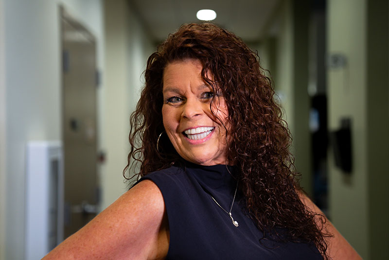 headshot of patient smiling brightly after their dental procedure