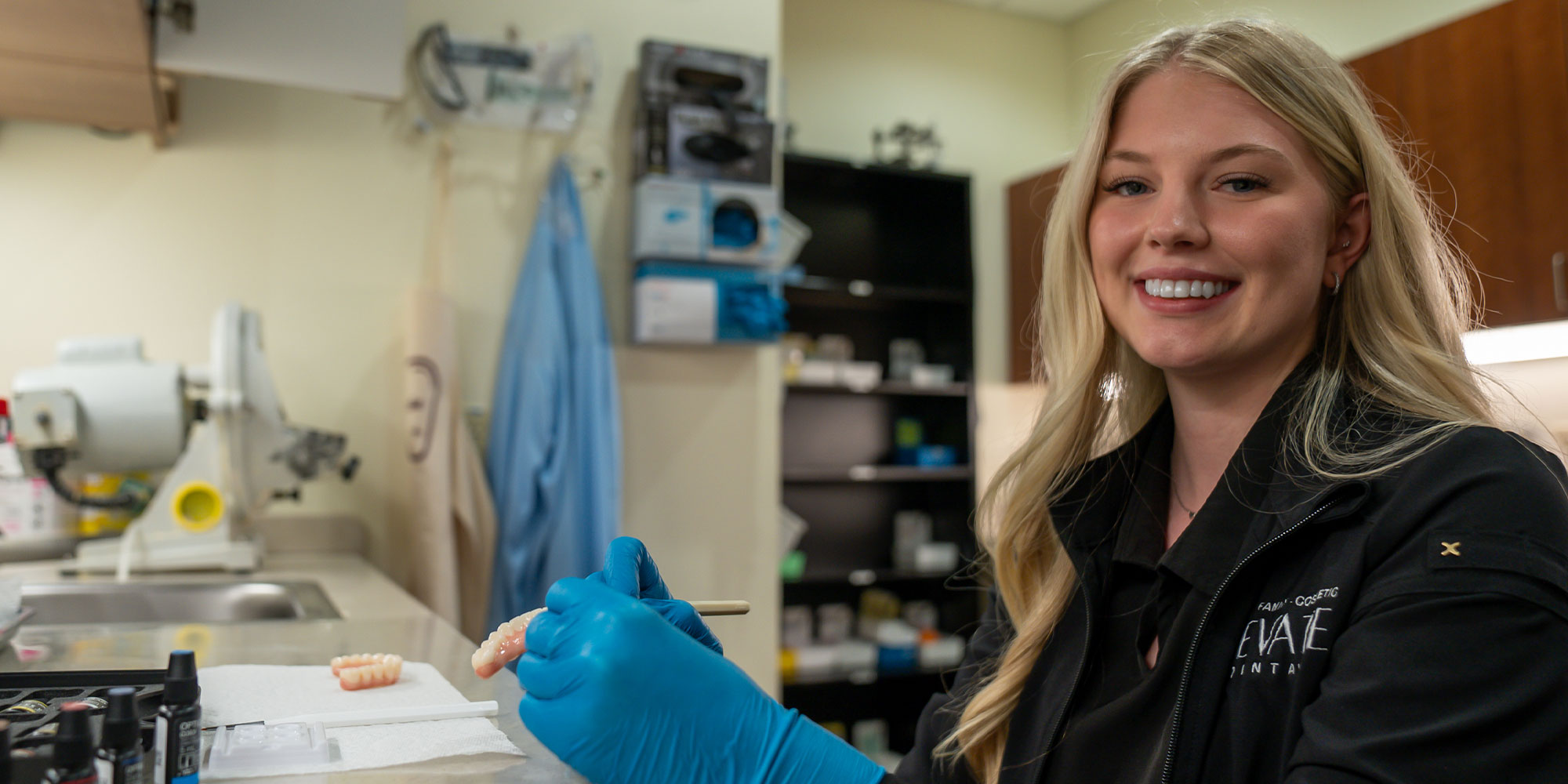 staff member showcasing a dental implant model